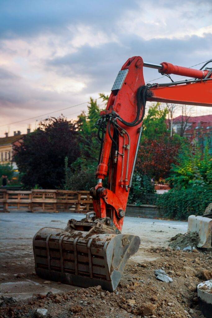 Excavator bucket digging ground for installing pipes at the street