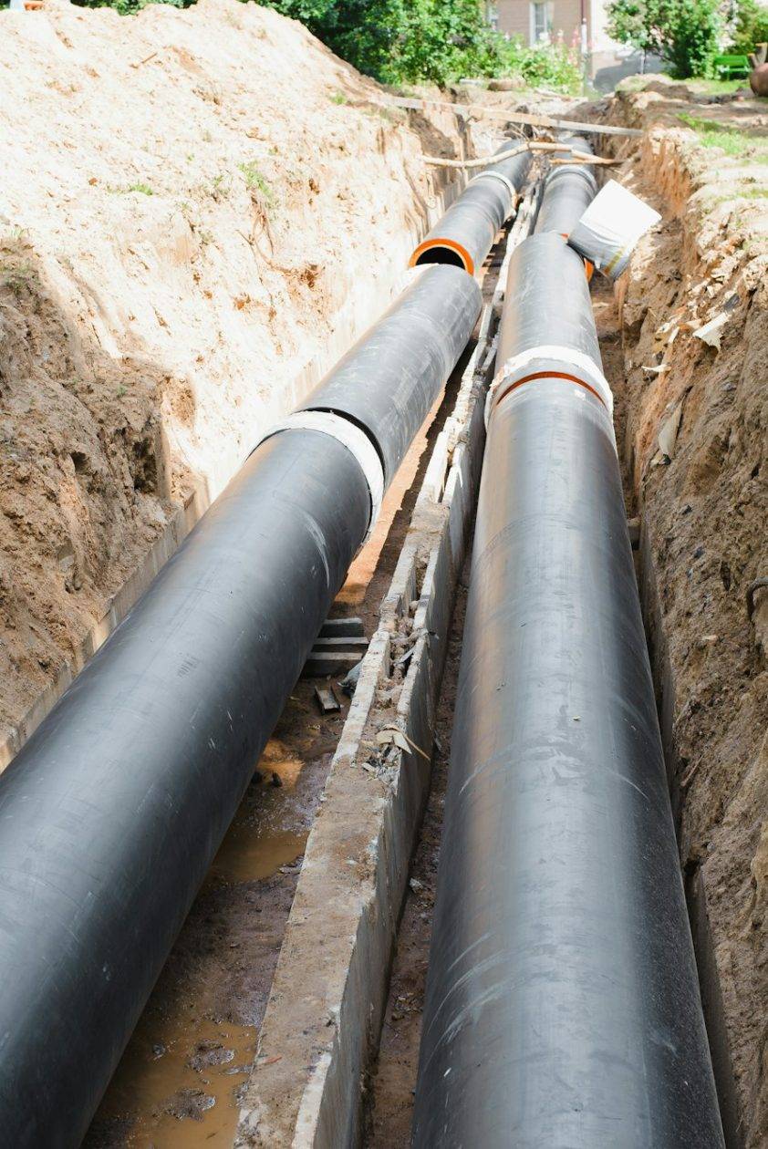 Plumbing repair. Installation of new industrial street water pipes in dug hole in two lines, outdoor Plumbing repair. Installation of new industrial street water pipes in dug hole in two lines, outdoor